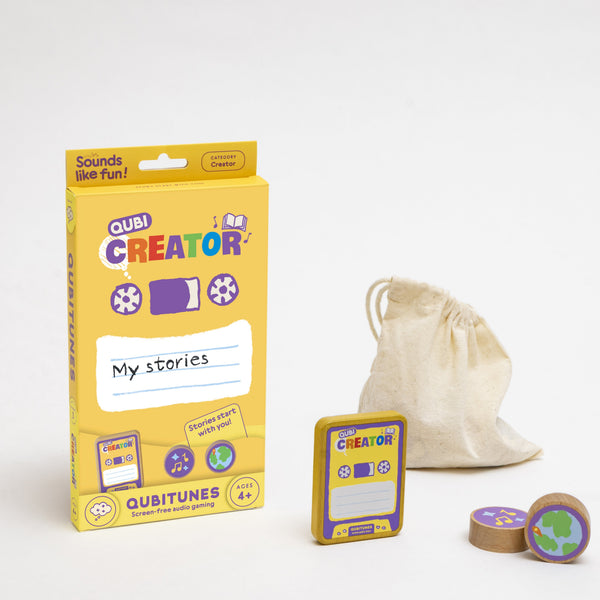 Geltona Qubi Creator dėžutė, žaidimo kortelė, drobinis maišelis ir dvi apvalios medinės kaladėlės