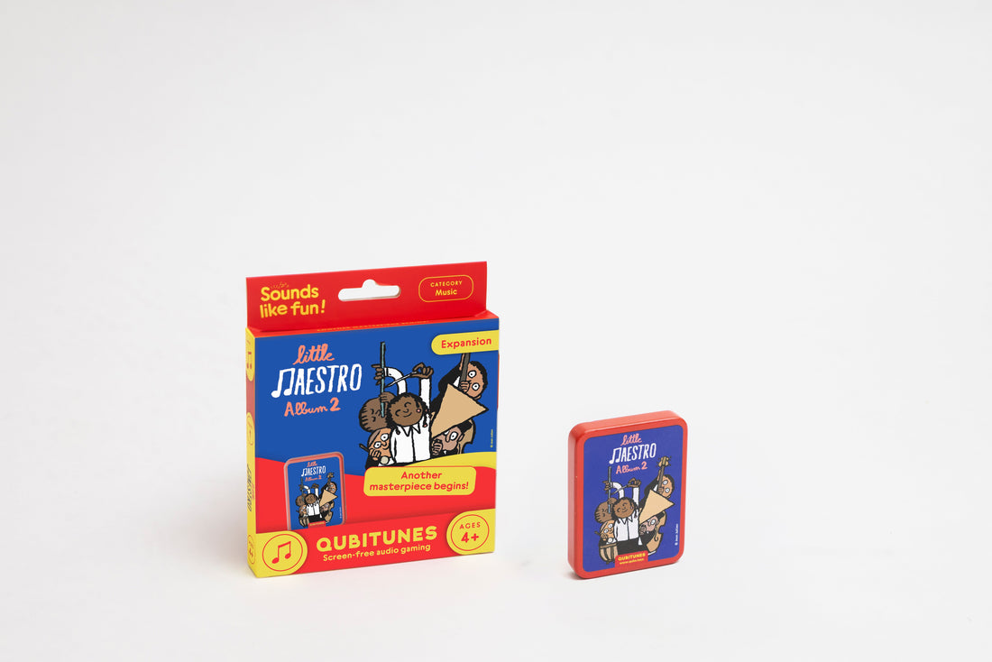 Little Maestro Album 2 plėtinio pakuotė ir šalia jos stovinti mėlyna medinė žaidimo kasetė